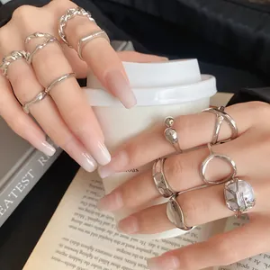 Detail shot of various minimalist irregular geometric silver open rings on hands