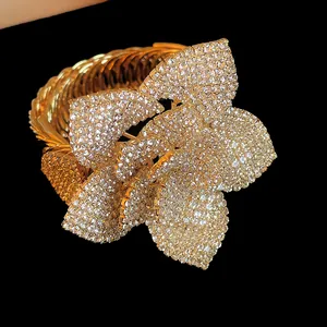 Close-up of luxury gold-toned flower bracelet with full rhinestone pavé setting