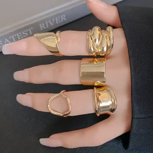 Detailed macro view of fashionable gold irregular geometric rings worn on fingers
