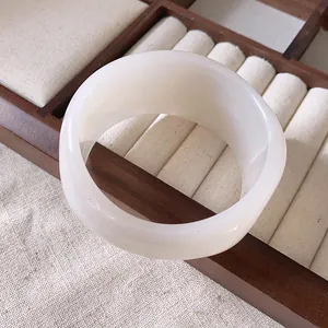 Vista dettagliata di un ampio bracciale in resina bianco latte con finitura liscia