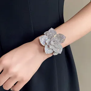 Detailed shot of a sparkling 3D flower cuff bracelet encrusted with crystals on a wrist.