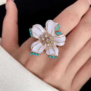 Elegant white enamel flower ring with sparkling rhinestones and turquoise beads