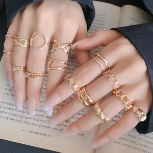 Detailed view of gold minimalist geometric and heart shaped open rings worn on hands