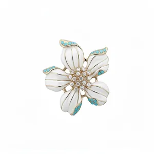 Elegant vintage-style flower pendant with white enamel petals and turquoise bead accents.