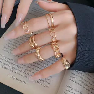 Detail view of assorted gold-finish geometric and heart-shaped rings worn on fingers