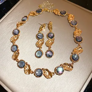 Close-up of vintage jewelry set with iridescent resin stones and textured gold finish.