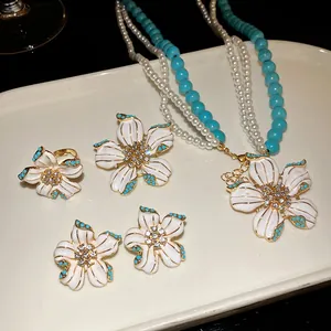 Vintage jewelry set featuring pearl turquoise beads and rhinestone flower pendant
