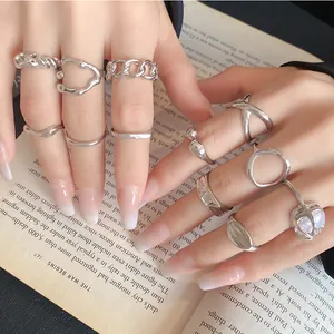 Detailed view of various silver-tone irregular geometric open rings on a book background