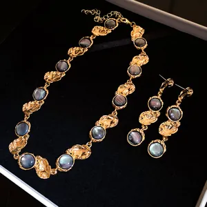 Detailed view of vintage palace-style gold necklace and earrings with grey resin inlays