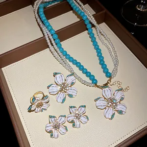 Elegant detail of flower jewelry set with pearls and turquoise beads in a gift box.