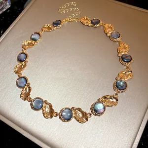 Vintage resin necklace featuring iridescent blue stones and gold-toned textured metal links.
