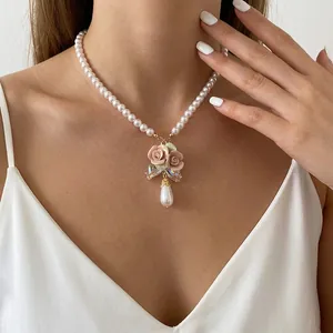 Elegante weiße Perlenkette mit Keramikrosen und schillerndem Schleifenanhänger für Damen