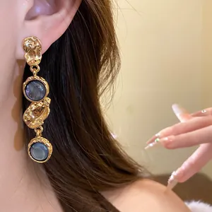 Macro view of elegant vintage court-style gold earrings featuring dark circular resin stones