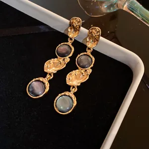 Detailed view of vintage gold palace style earrings featuring marbleized grey resin inlays