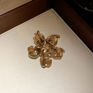Detailed back view of a vintage style golden floral pendant showing pin mechanism and texture