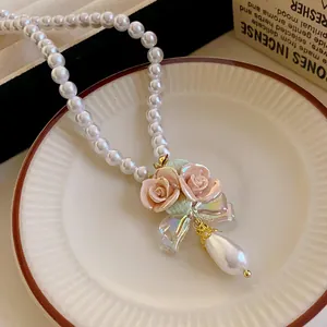 Elegante Perlenkette mit rosa Keramikrosen-Anhänger und holografischer Schleife