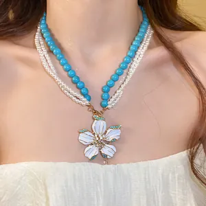 Detail view of vintage pearl necklace set with turquoise beads and flower pendant