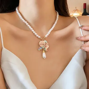 Elegante französische Perlenhalskette mit rosa Keramikblumenanhänger und Tropfenperlen-Detail