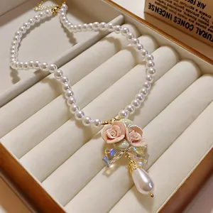 Detailansicht einer eleganten Perlenkette mit Keramikrosen und Tropfenperle