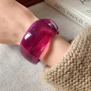 Vista dettagliata di un ampio bracciale in resina viola irregolare con trama artistica