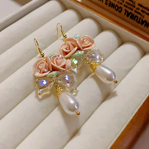 Nahaufnahme von französischen Vintage-Ohrringen mit rosa Keramikrosen und Perlen
