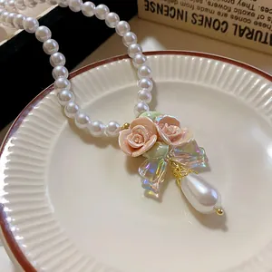 Detail der eleganten Keramikrose und des Tropfenperlenanhängers an einer Perlenkette