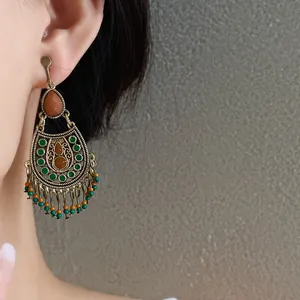 Close-up of vintage ethnic tassel earrings featuring oil-drop waterdrop beads and gold finish