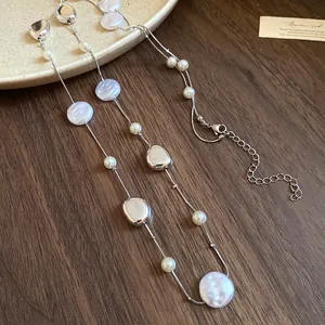 Detailed shot of a French retro pearl and silver bead necklace on a wooden background.