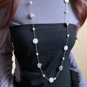 Close-up detail of long French vintage necklace with pearls and metallic beads