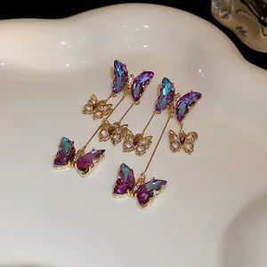 Boucles d'oreilles papillon avec cristaux violets dégradés et zircons sur finition or.