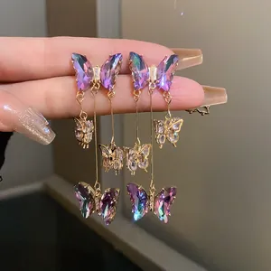 Gros plan d'élégantes boucles d'oreilles papillon en cristal violet avec des touches de zircon
