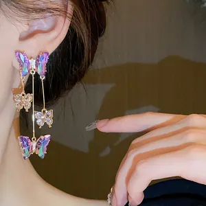 Vue macro de boucles d'oreilles papillon en cristal avec strass violets élégants