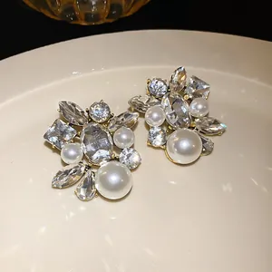 Makrodetail luxuriöser französischer Ohrringe mit Silbernadeln, Perlen und Strasssteinen