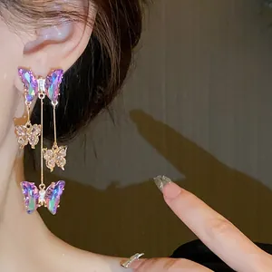 Gros plan d'élégantes boucles d'oreilles papillon en cristal violet avec détails zircon.