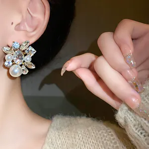 Detailansicht eines luxuriösen Ohrrings mit eingelegten Kristallen und Perlen