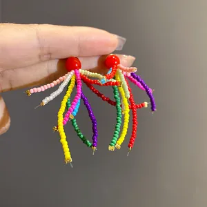 Detailansicht farbenfroher Perlenohrringe mit einem roten Harzstecker-Sockel.