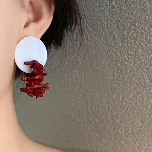 Nahaufnahme von Retro-Resin-Ohrringen mit weißem Kreis und roten unregelmäßigen Details