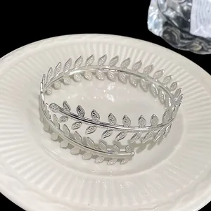 Vista dettagliata di un elegante bracciale a foglia d'argento su piatto ceramico