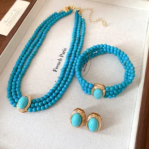 Detail shot of vintage multi-layer turquoise bead necklace set on a cream display tray