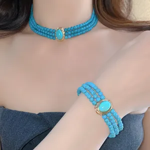 Detailed view of multi-layer turquoise beaded necklace and matching bracelet on model