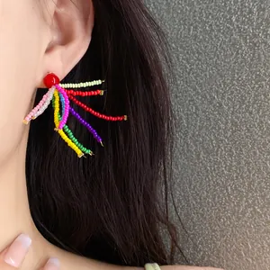 Nahaufnahme von handgefertigten Perlenohrringen mit farbenfrohem Sprühdesign am Ohr