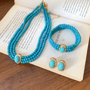 Detailed view of vintage turquoise beaded necklace, bracelet, and earring set on a book.