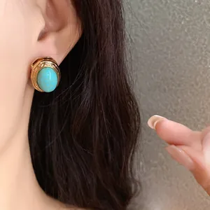 Close-up detail of a vintage turquoise stone earring with gold textured setting.