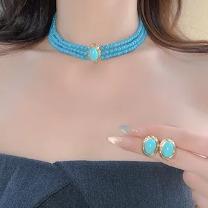 Close-up of vintage multi-strand turquoise beaded choker and matching stud earrings for women.