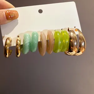 Detailed view of fashion earring set featuring resin and metallic gold hoops
