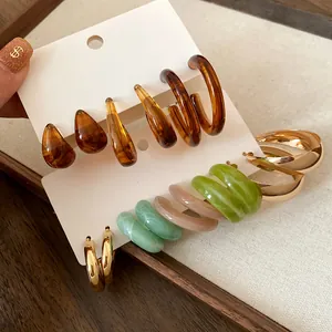 Detailed macro view of assorted resin and gold-tone hoop earrings sets on display cards
