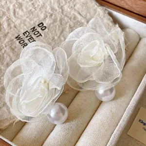 Detailed view of elegant white mesh flower stud earrings featuring large round faux pearls
