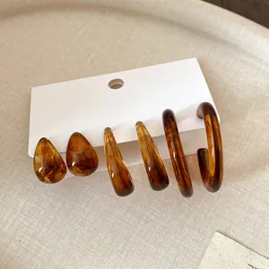 Set of retro amber tortoise shell resin earrings including hoops and teardrop studs.