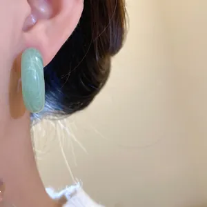 Detailed close-up view of elegant retro green marbled resin hoop earrings with silver needles.
