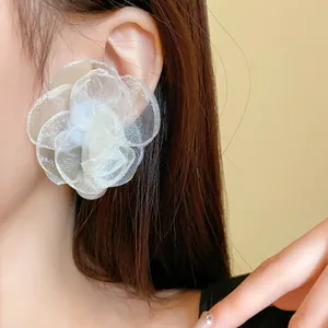 Detailed close-up view of an elegant white mesh flower earring with a pearl center